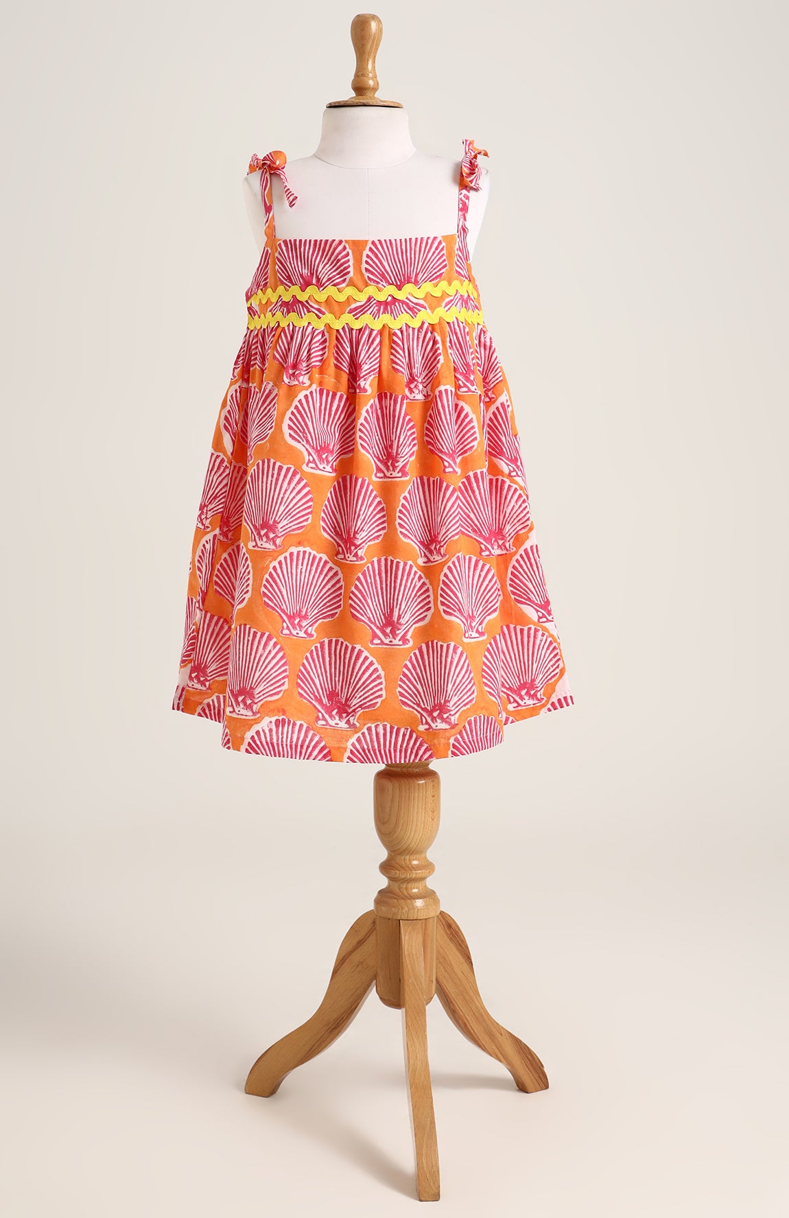 Printed cotton dress. Detailed with colourful strings on shoulder and  tied bow straps.