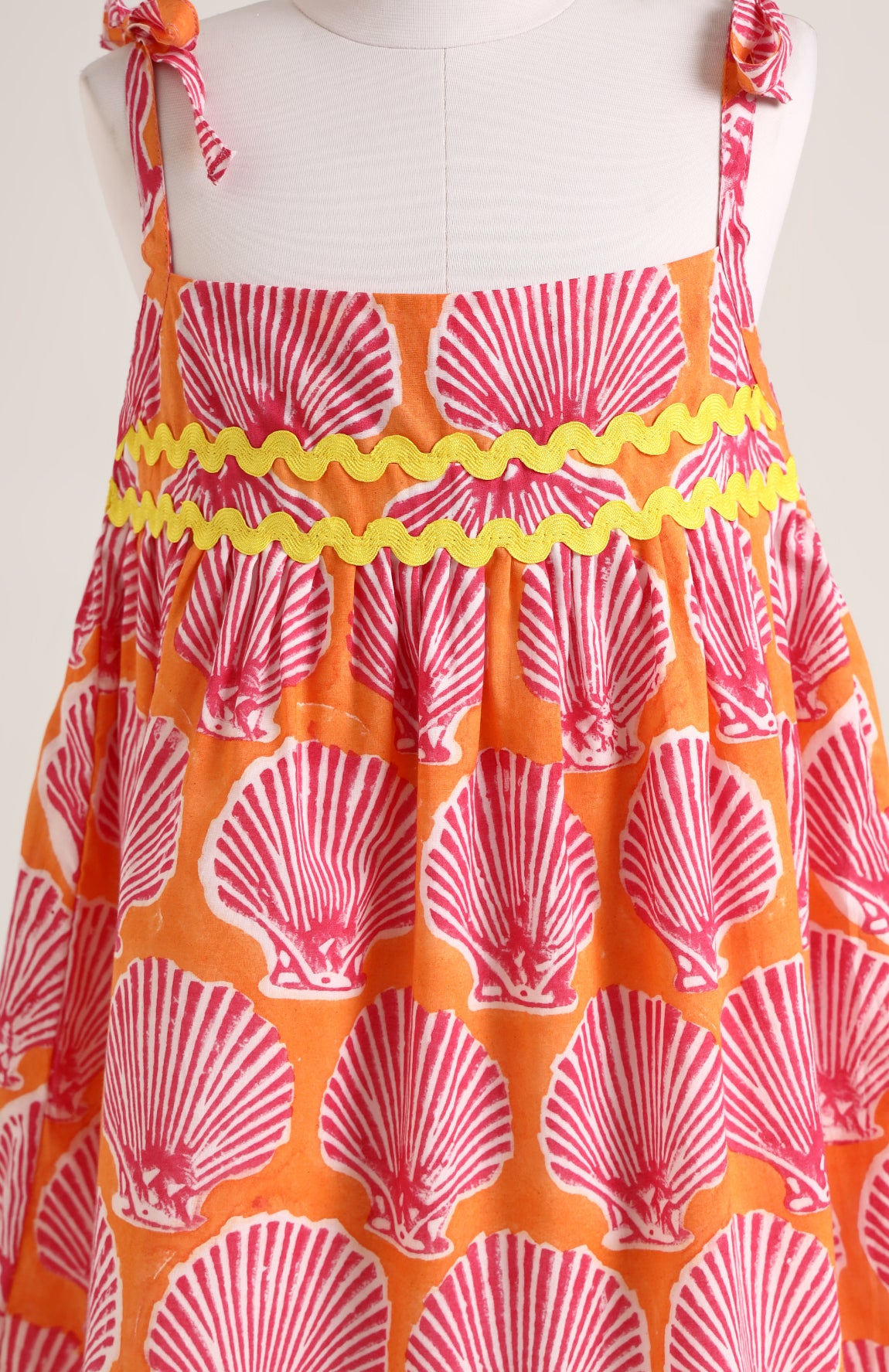 Printed cotton dress. Detailed with colourful strings on shoulder and  tied bow straps.