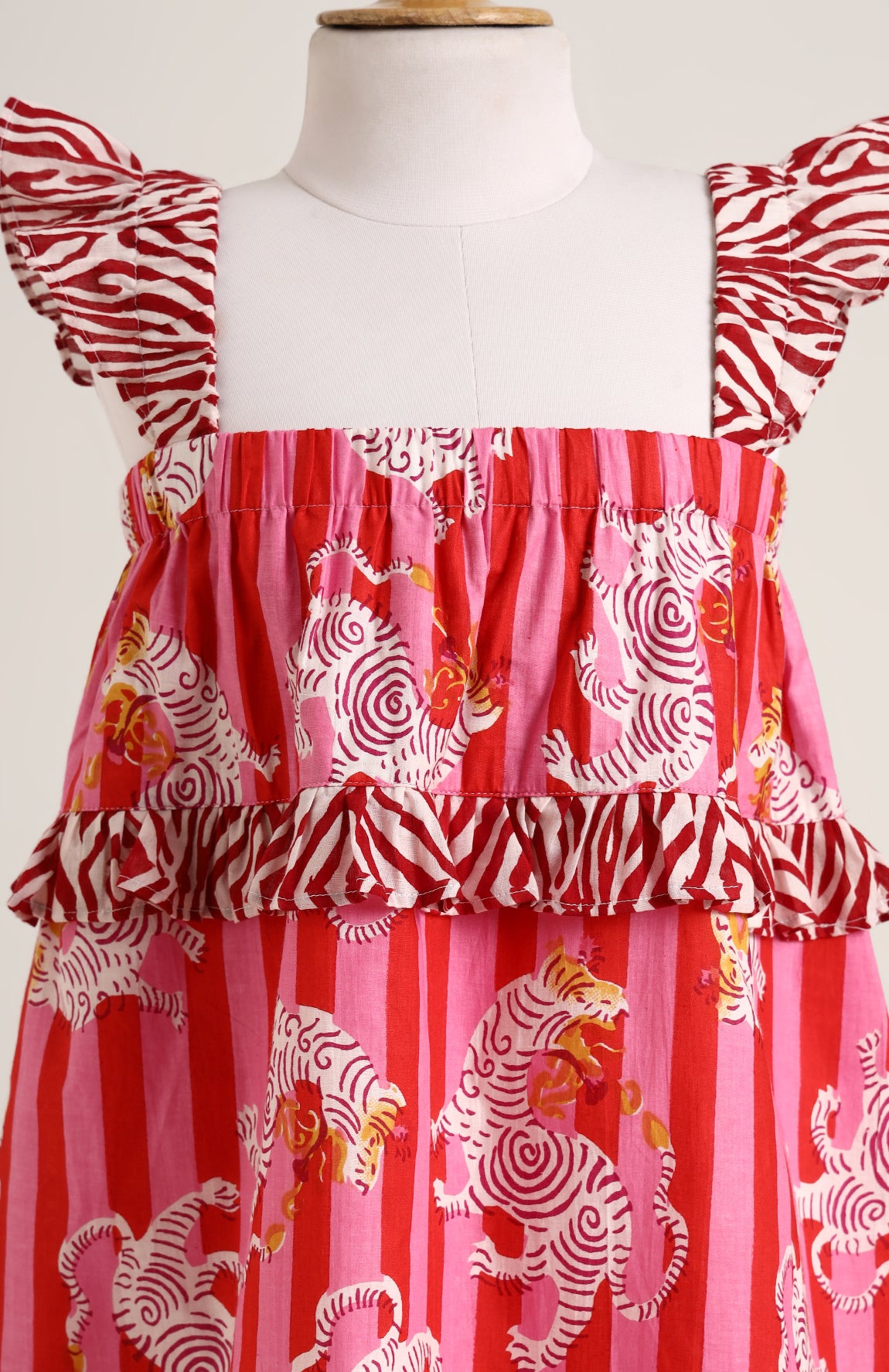 Printed cotton sleeveless dress. Detailed with frils on shoulder and waist