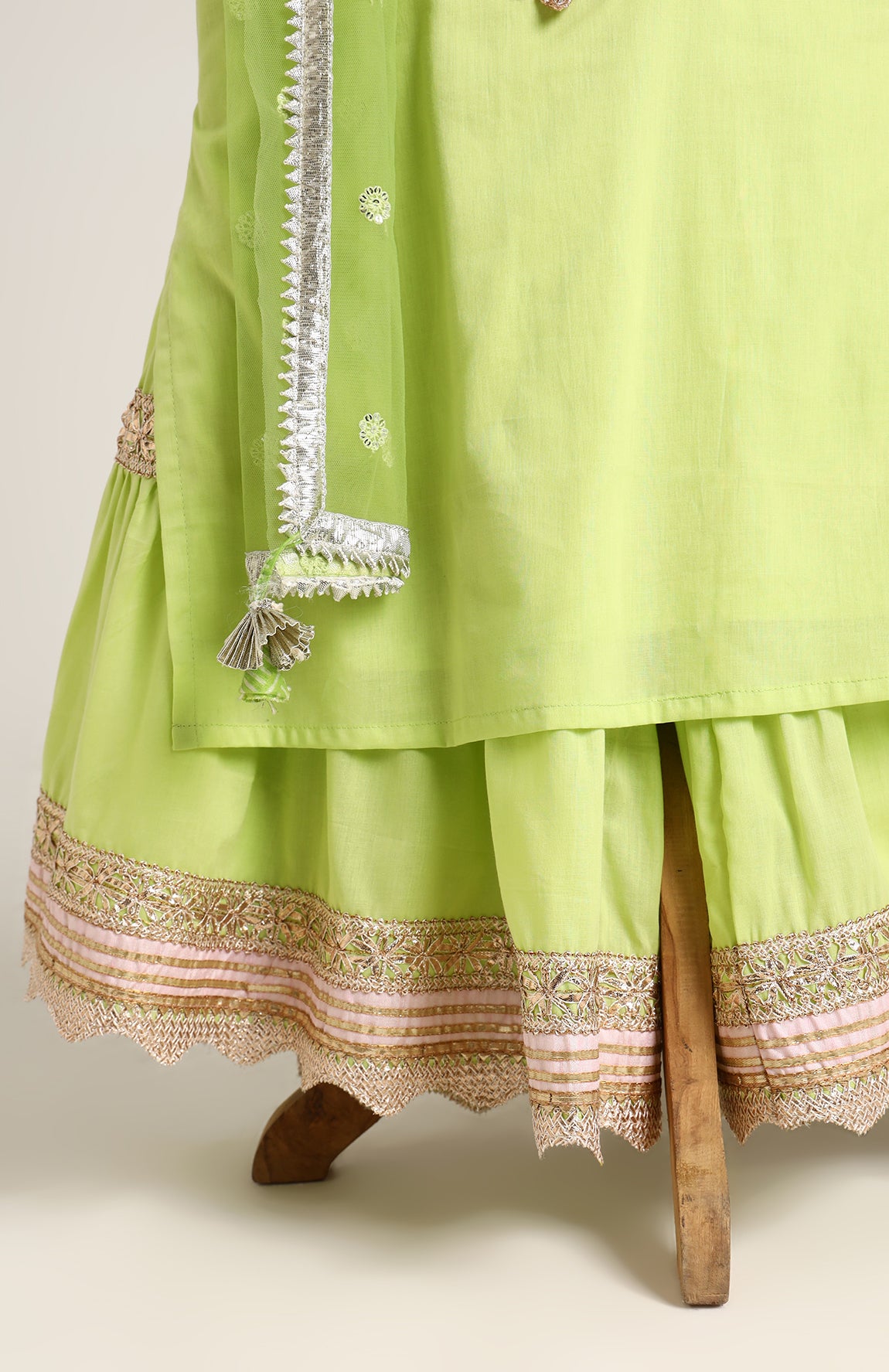 Mulmul Plain Kurta and Sharara paired with Soft Net dupatta. Detailed with big Neck Patch and Gota Patti/Lace