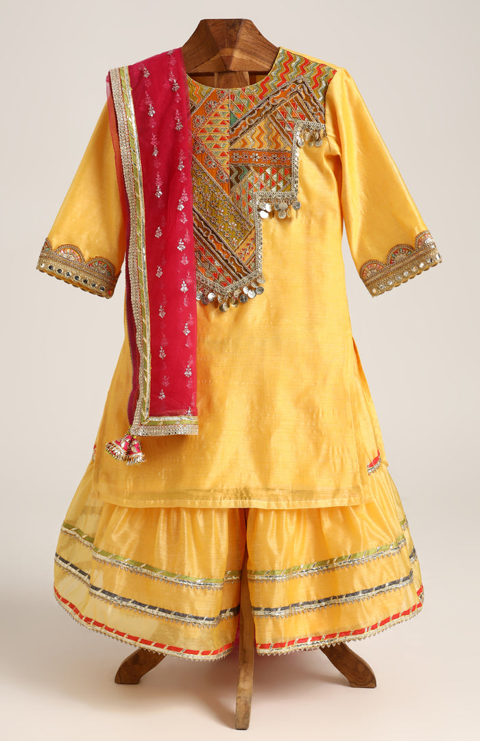 Chanderi Plain Kurta and Sharara paired with Soft Net dupatta. Detailed with big Neck Patch and Gota Patti/Lace