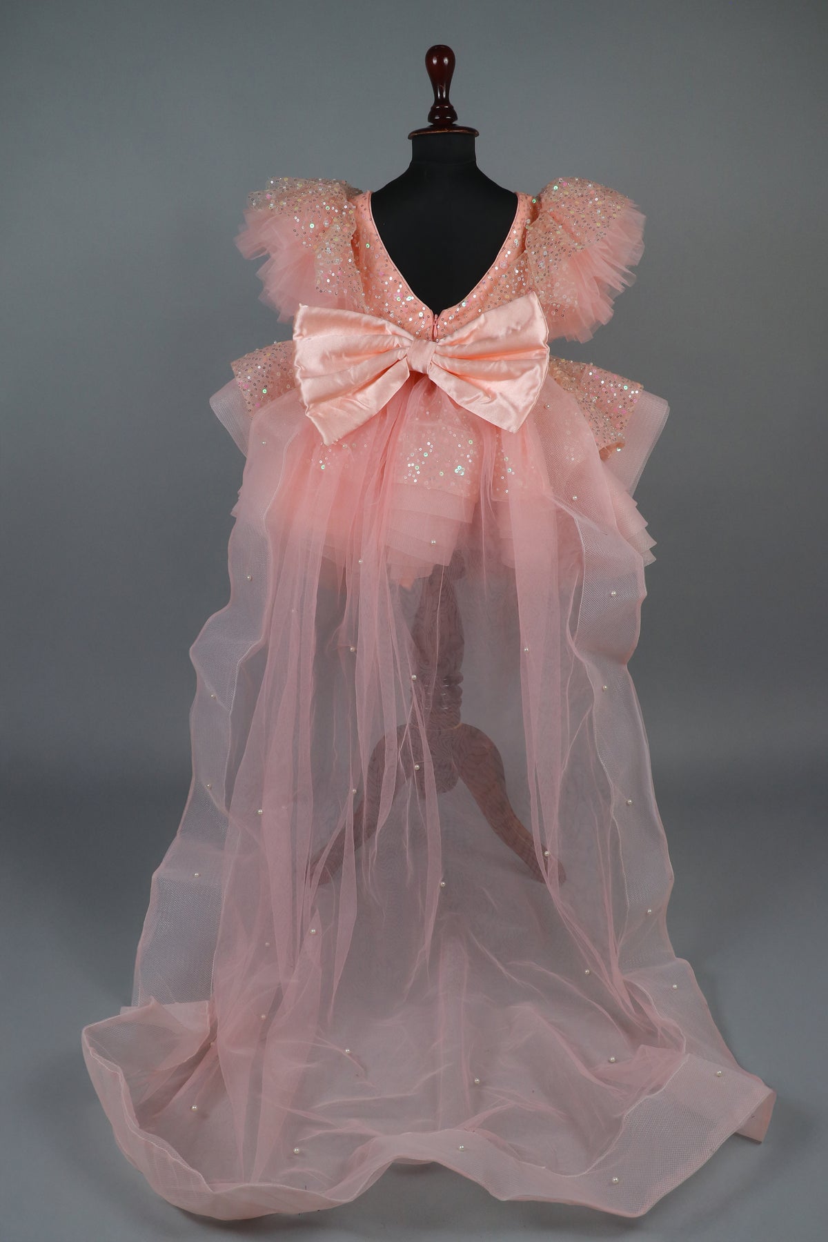 peach sequence embellised dress featurling a detachable trail and bow with swired bow headband